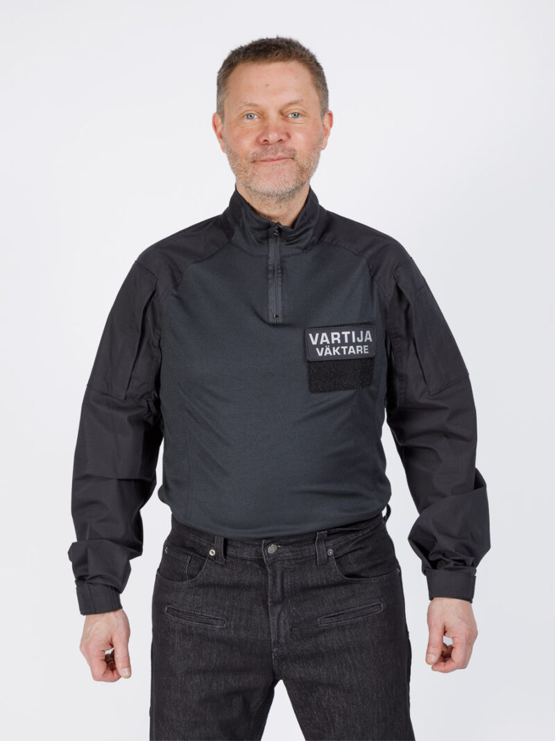 Origopro musta taistelupaita vartijoille ja turvallisuusalalle. Mukava liivin alla, Coolmax-Fresh® siirtää kosteutta ja estää hajua. Vetoketjulliset taskut ammattikäyttöön.